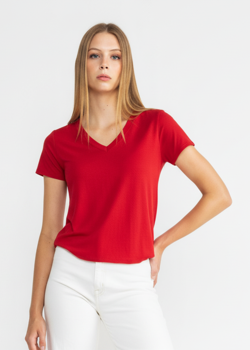 Woman wearing a red shirt and white pants on a white background