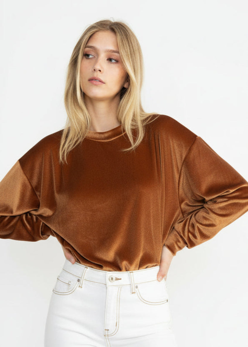 Woman wearing a brown velvet top against a white background