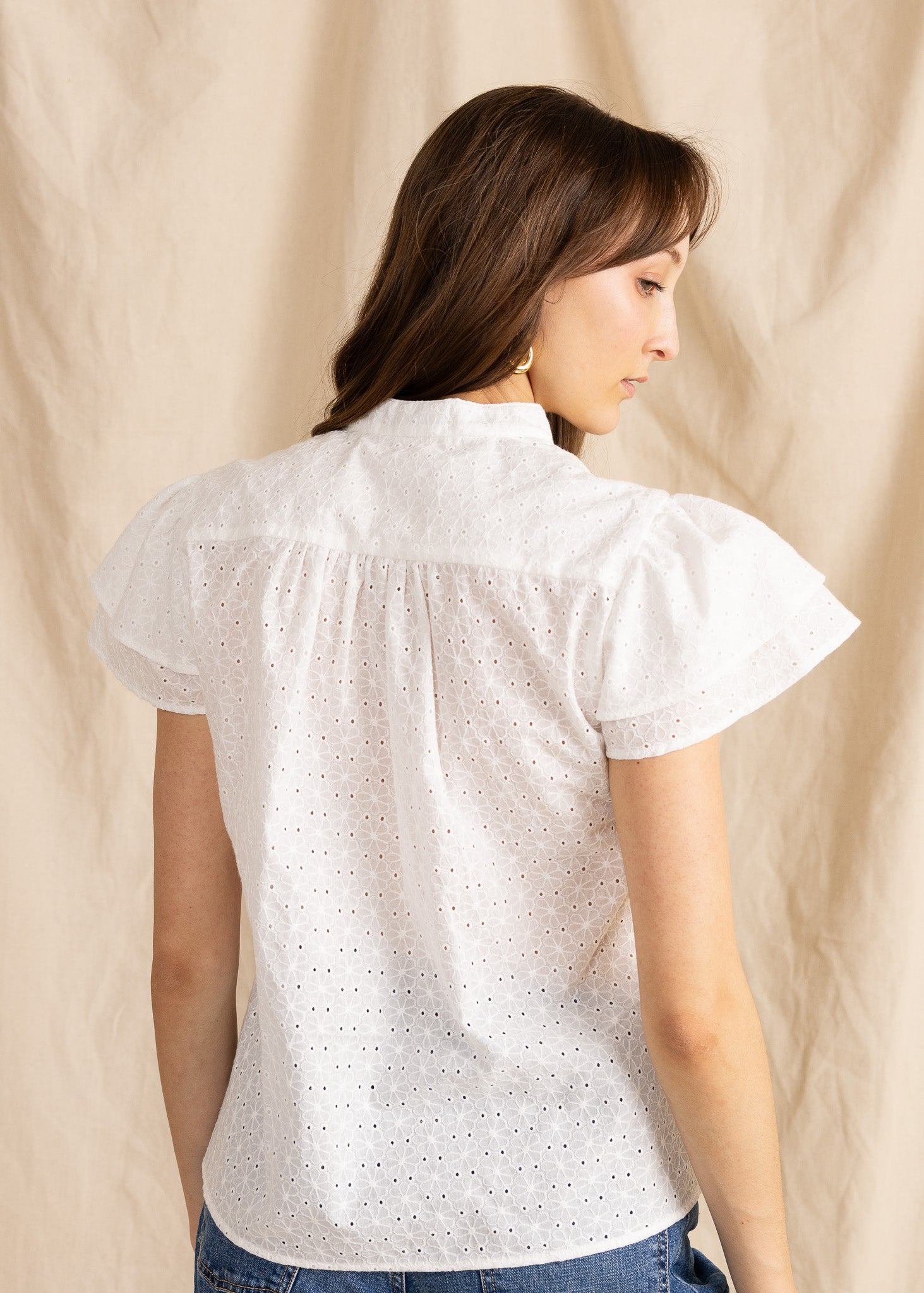 Yana K georgette top featuring intricate eyelet detailing and a flowing silhouette in a soft color.