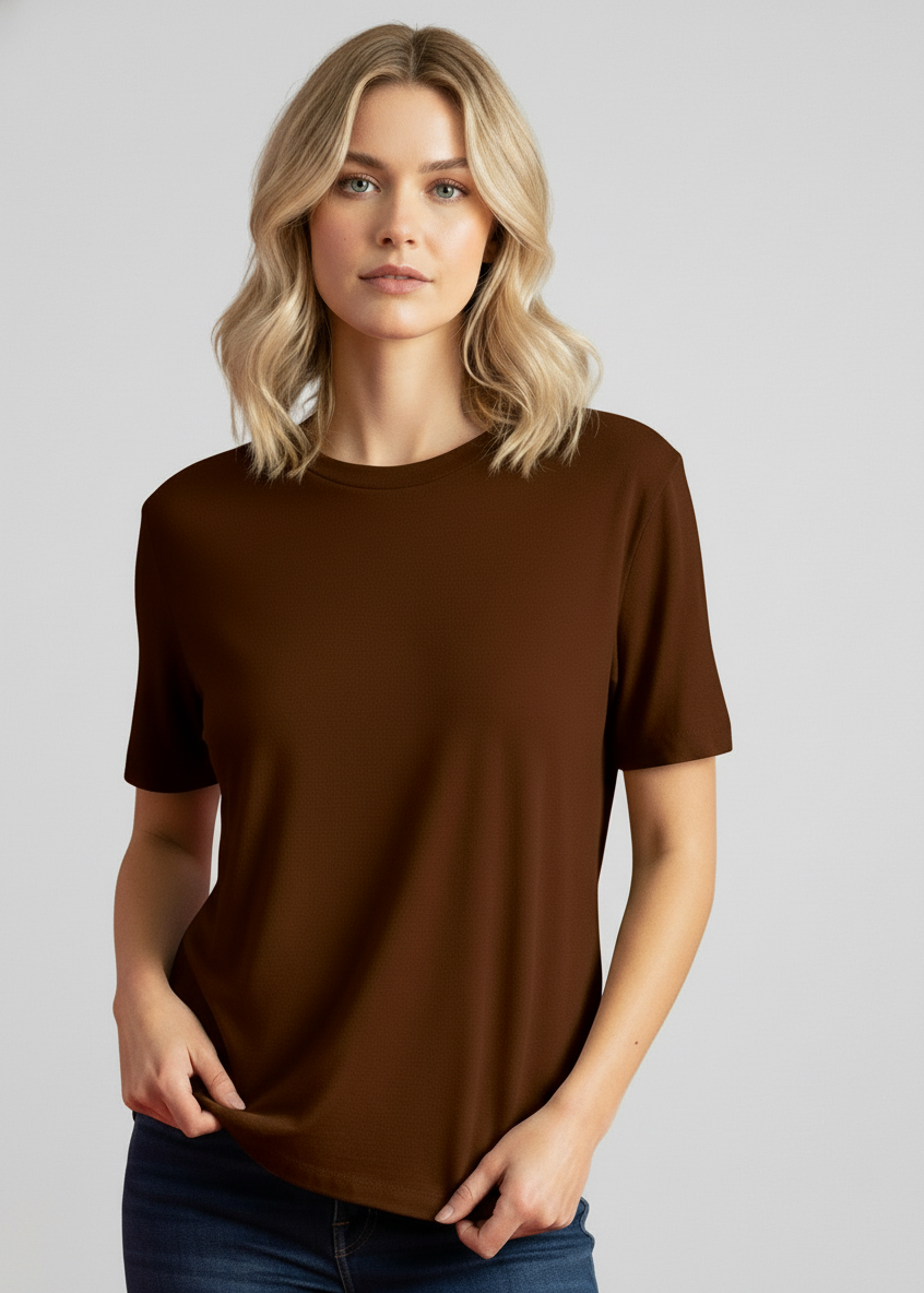 Woman wearing a brown t-shirt and blue jeans against a gray background