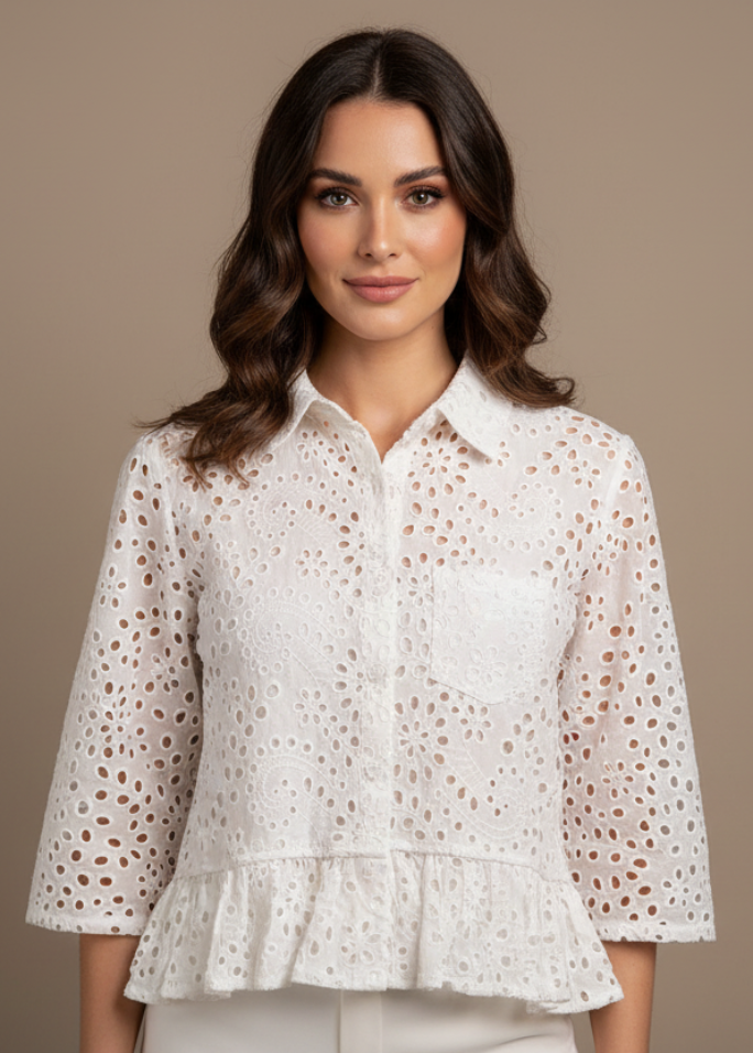 Woman wearing a white blouse with a subtle pattern on a brown background