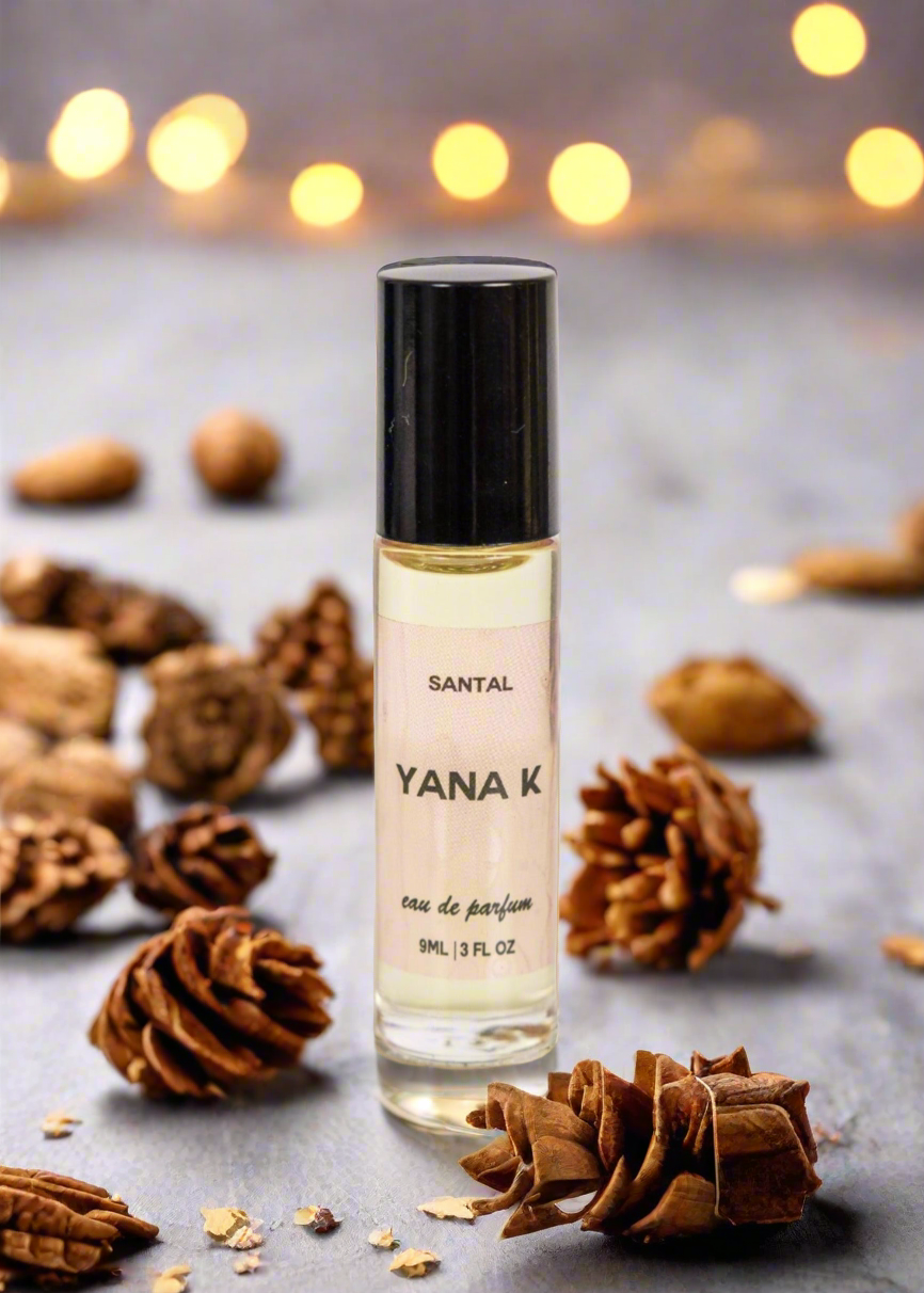 Yana K EAU DE PARFUM - SANTAL bottle with elegant design, showcasing warm amber liquid and silver cap on a soft background.