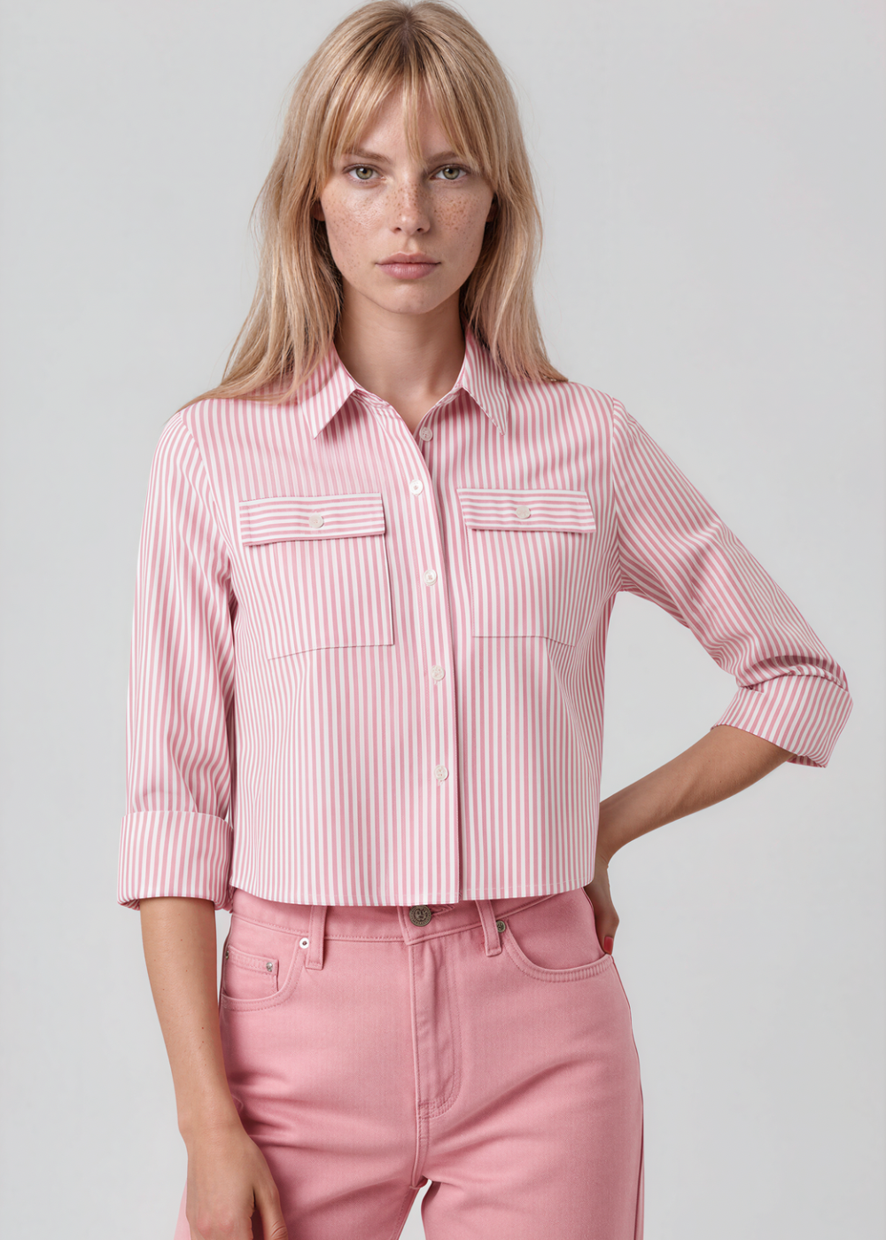 Woman wearing a pink stripe shirt and pink pants on a gray background