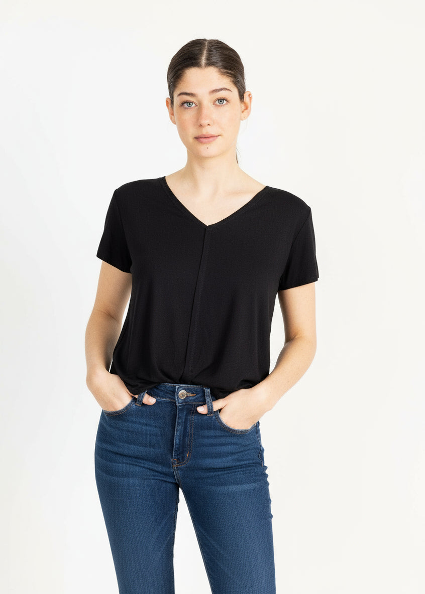 A woman wearing a black teeshirt, posing against a white background.