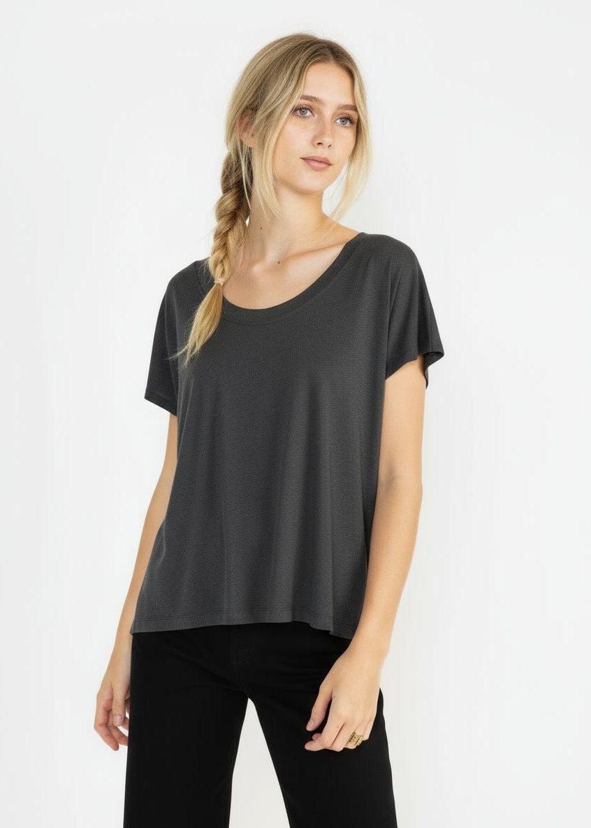 Woman wearing a charcoal t-shirt and black pants on a white background