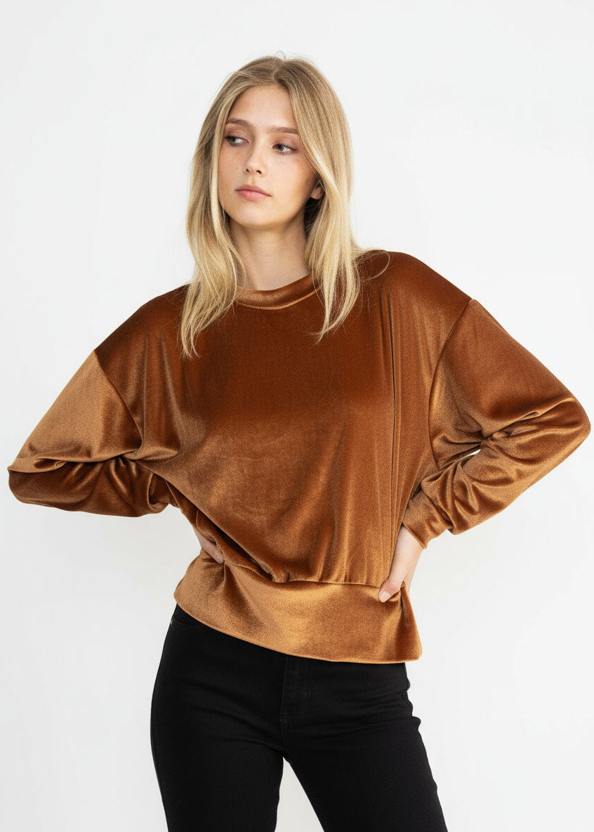 Woman wearing a brown velvet top against a white background