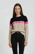 Woman wearing a black, pink, and beige sweater with a white background
