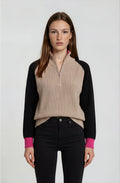 Woman wearing a black and beige sweater with a white background