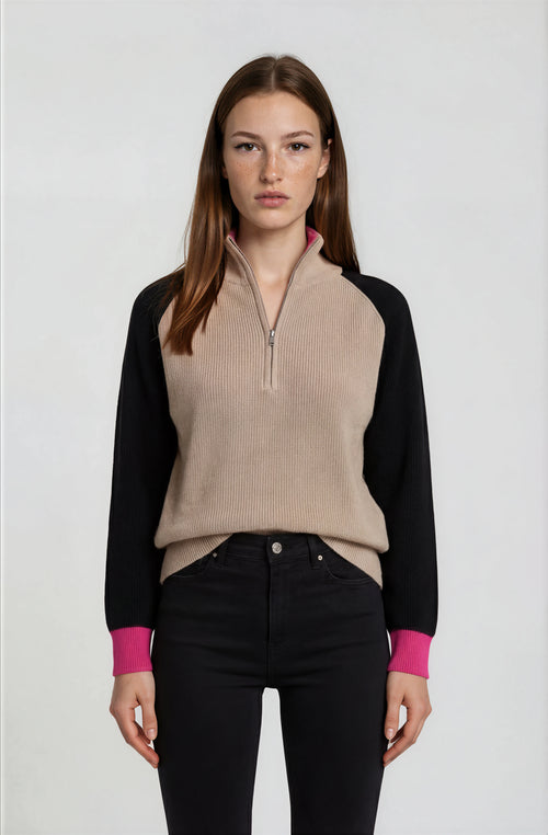 Woman wearing a black and beige sweater with a white background