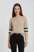 Woman wearing a beige cardigan with black and white stripes on a white background