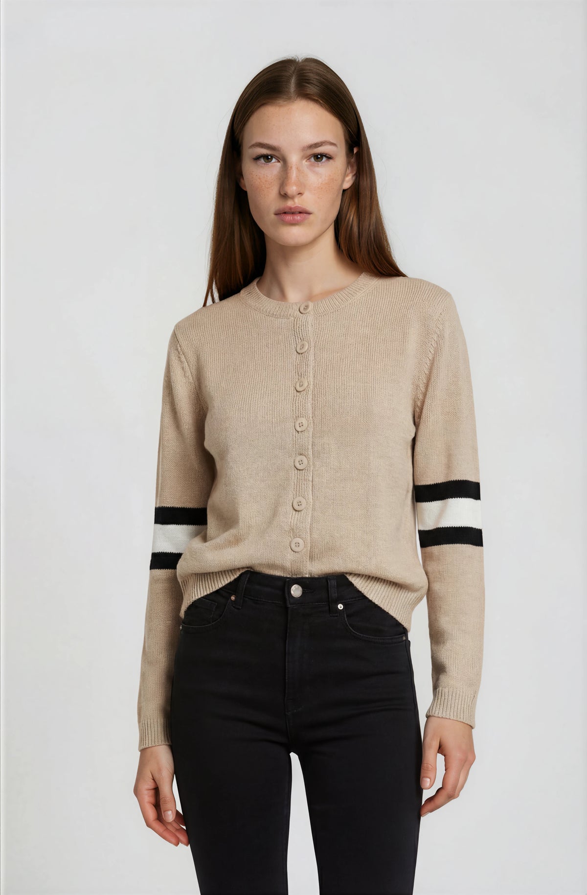 Woman wearing a beige cardigan with black and white stripes on a white background