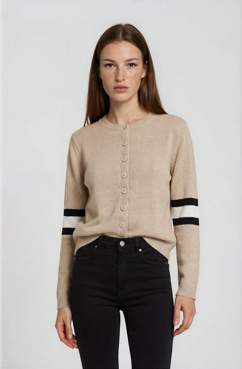 Woman wearing a beige cardigan with black and white stripes on a white background