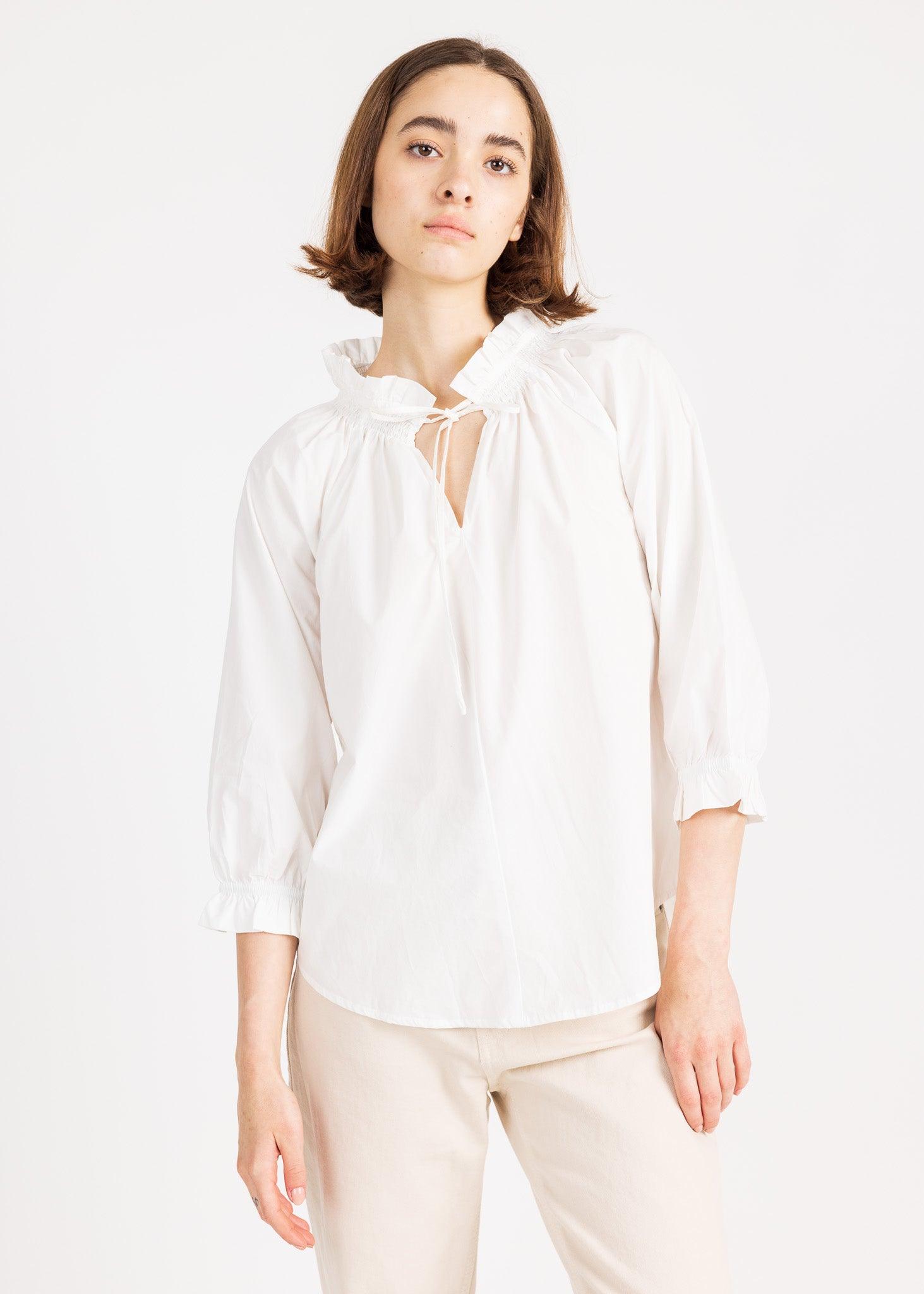 Soft cotton top with hand-smocked neckline and spaghetti straps, offering a touch of bohemian style.