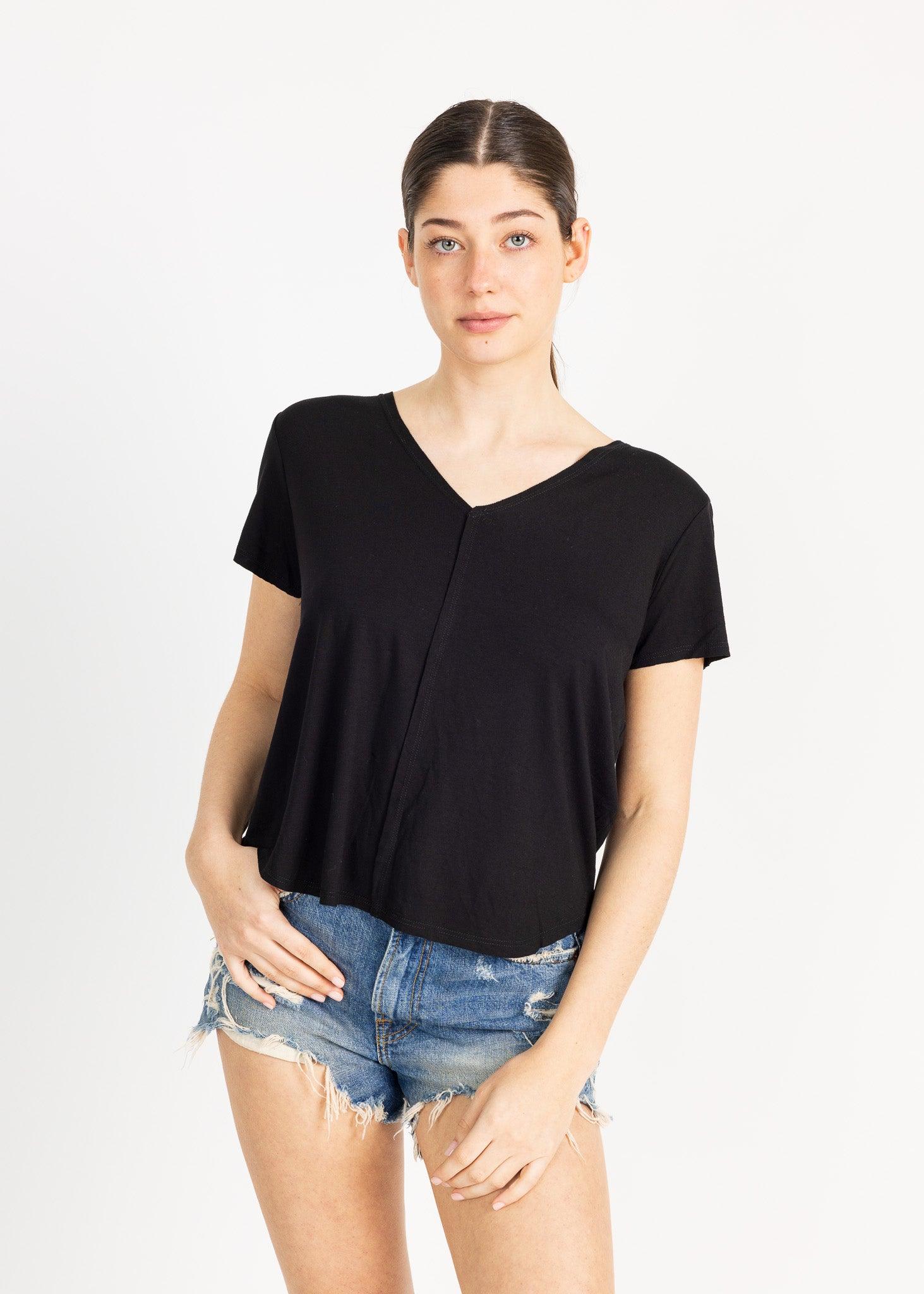 A woman wearing a black blouse, posing against a white background.