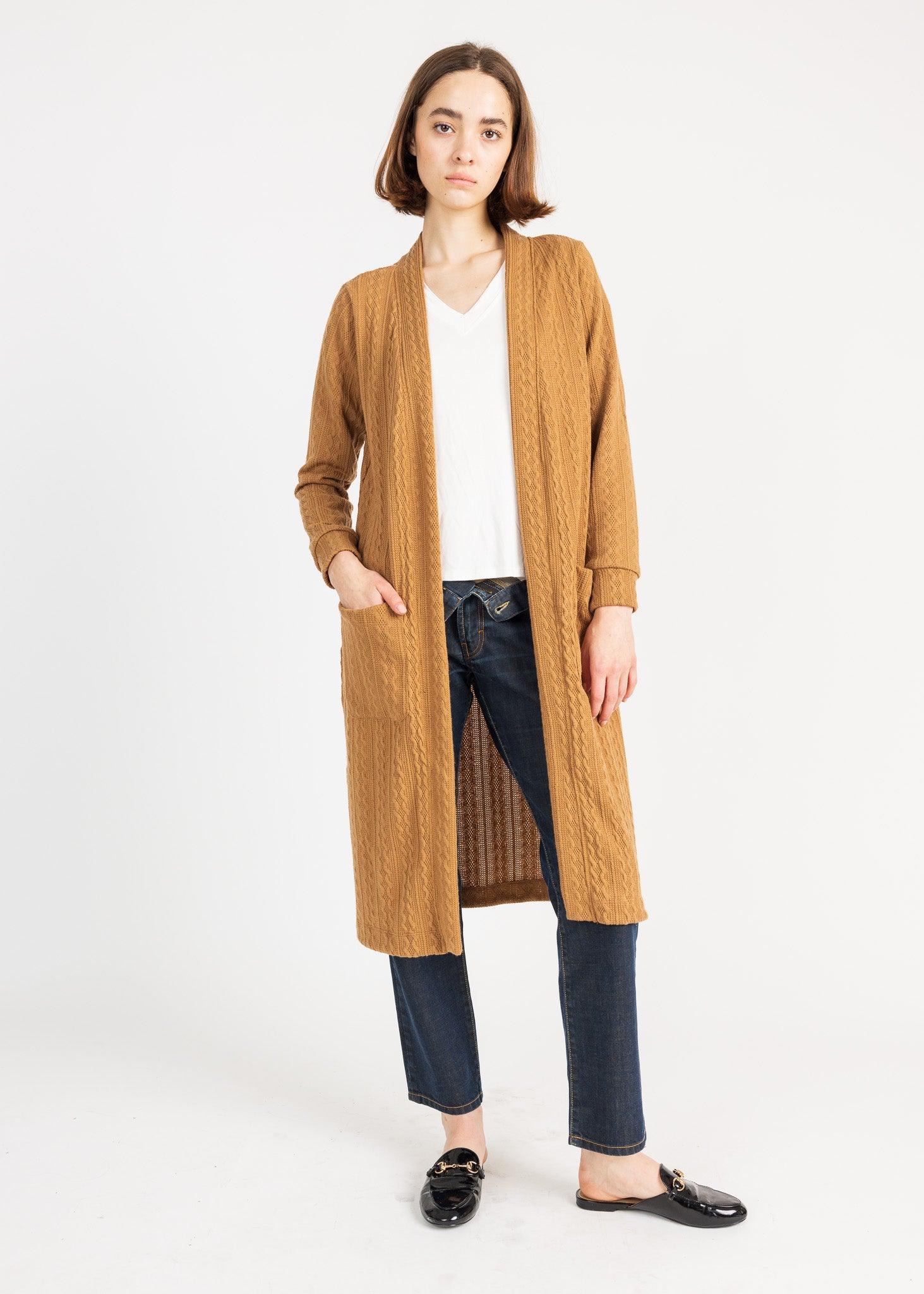Long knit cardigan in a warm, earthy tone with pockets, adding both style and practicality to the wearer's outfit.